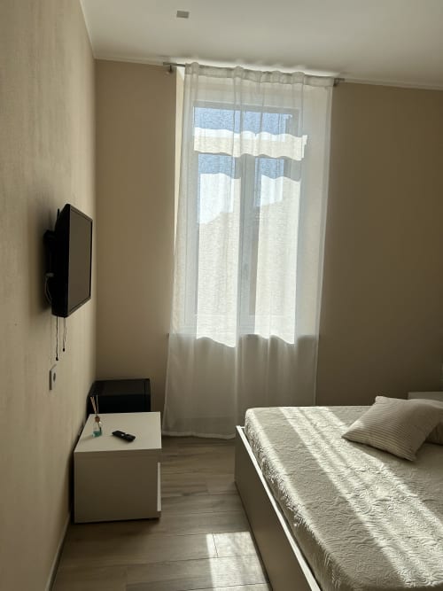Camera moderna al Breccia nel Mare B&B di Marina di Carrara con letto, TV a parete, scrivania e finestra dal pavimento al soffitto