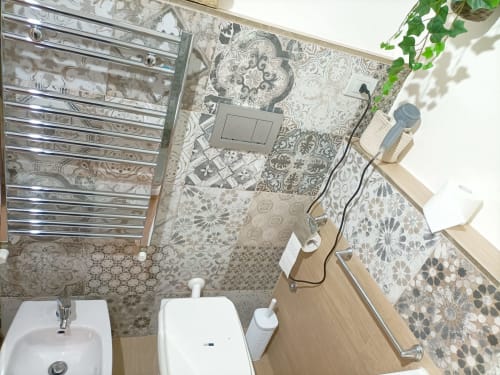 Bagno della villa Newhouse a Bari con piastrelle decorative, lavabo, wc, scaldasalviette e moderni arredi