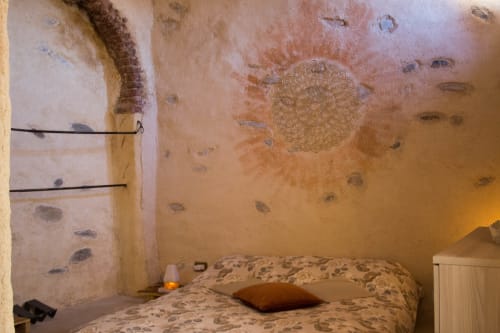 Cozy bedroom at CasaRosada B&B in Vidracco with patterned bedding and decorative ceiling art