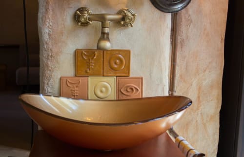 Artistic copper sink with decorative tile backsplash and brass faucet at CasaRosada bed and breakfast in Vidracco, Italy
