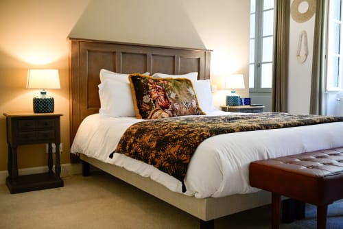 Chambre élégante du spa-hôtel Pavillon Des Millésimes à Lussac avec tête de lit en bois, draps blancs et plaid décoratif