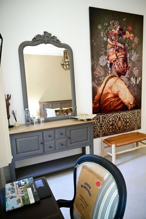 Elegant bedroom vanity with ornate mirror and portrait artwork at Pavillon Des Millésimes in Lussac