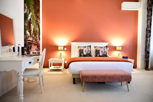 Elegant bedroom at Pavillon Des Millesimes with coral walls, white bed, floral pillows, and modern amenities in Lussac