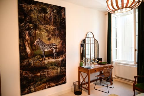An elegant room at the Pavillon Des Millésimes featuring a wooden headboard, a palette of greens, a green armchair, and views of the pool and landscaped garden