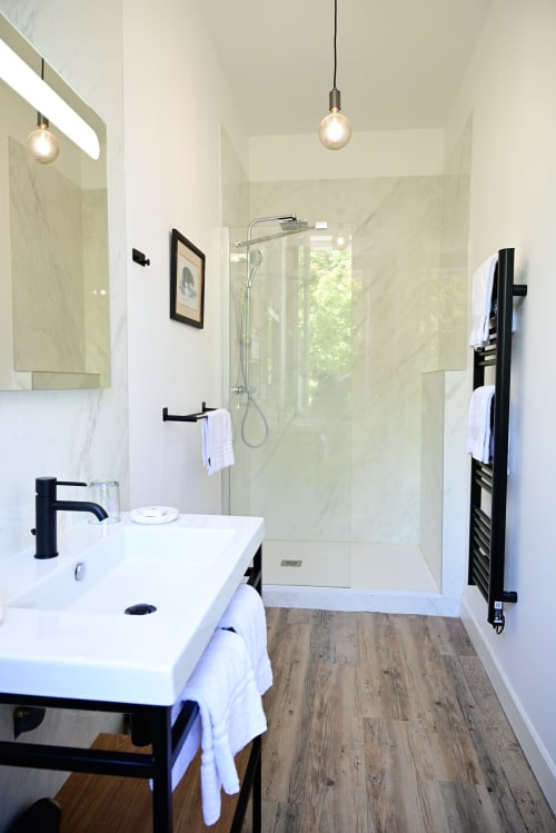 Modern bathroom in Pavillon Des Millesimes, Lussac with walk-in shower, mirror, and wood-look flooring