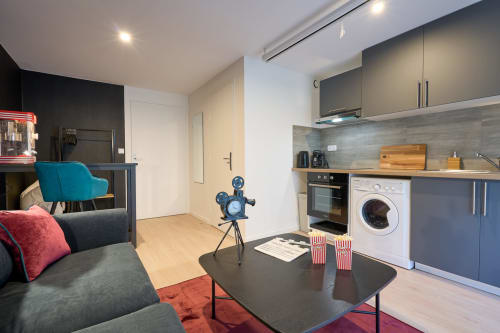 Cinema-themed studio apartment in Bordeaux with kitchen, washing machine, sofa and vintage movie projector decor