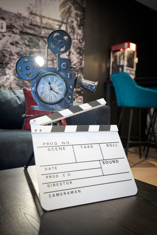 Movie projector clock and film clapperboard in Cinema-themed apartment at Wellkhome Bordeaux