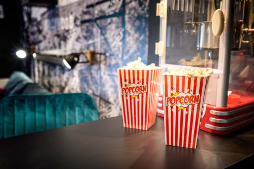 Two red-striped popcorn boxes on table in Cinema-themed studio apartment at Wellkhome Bordeaux with city view and flat-screen