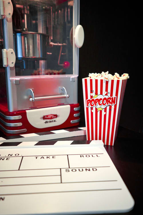 Vintage cinema-themed popcorn maker and classic movie clapperboard in Bordeaux apartment entertainment area
