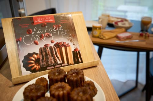 La Folie Cannelles cookbook displayed at Wellkhome apartments in Bordeaux with gourmet pastries on plate