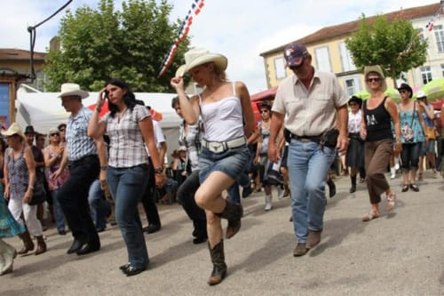 People in Western attire dancing at outdoor festival near Les Chalets Du Lac, Clarac France