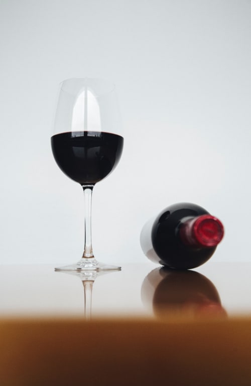 Calice di vino rosso con bottiglia, atmosfera lussuosa di B&B a Pisa