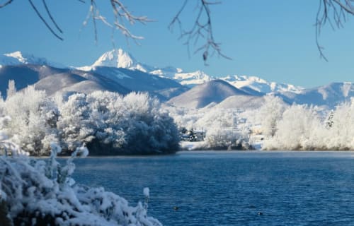 Lac de Montréjeau enneigé au premier plan avec les Pyrénées enneigées à l'arrière-plan 