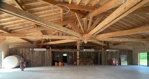 Plan panoramique de la salle d'événementiel de l'hôtel des Chalets de Montréjeau ayant une charpente en bois apparente ; équipée d'un vidéo projecteur, de climatisation et d'enceintes sur 360°.