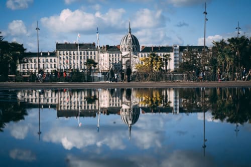 Élégants bâtiments en bord de l'eau avec dôme reflété dans l'eau calme, La Maison d'Olivier BnB à Mesnard-la-Barotière, France