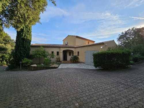 Façade du gîte Villa Sigahi à La Croix Valmer avec allée en pierre, murs en terre cuite et paysage verdoyant