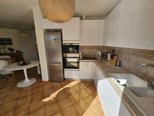 Moderne Küche mit weißen Schränken, Edelstahlgeräten und Holzarbeitsplatten im Cottage Villa Sigahi, La Croix