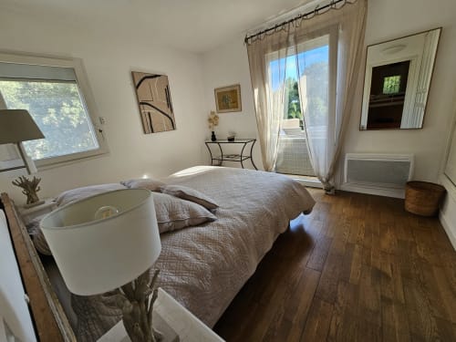 Helles Schlafzimmer in der Villa Sigahi in La Croix Valmer mit Queensize-Bett, Balkonzugang, Holzböden und Poolblick