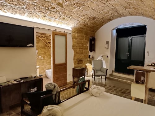Sottano 2 apartment at CorteLirice Paradiso with stone arches, bed, TV, kitchenette and modern amenities