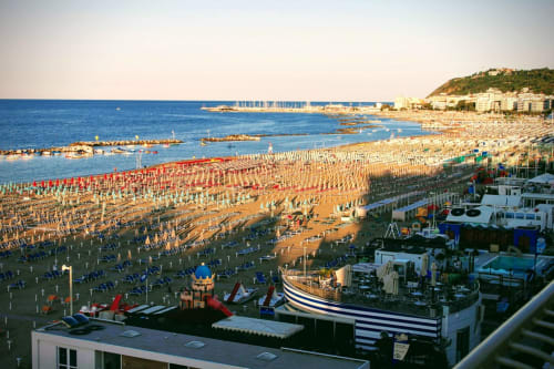 Spiaggia di Misano Adriatico con ombrelloni colorati, lettini e la posizione fronte mare degli Lamar Suites Seafront Apartments in Italia