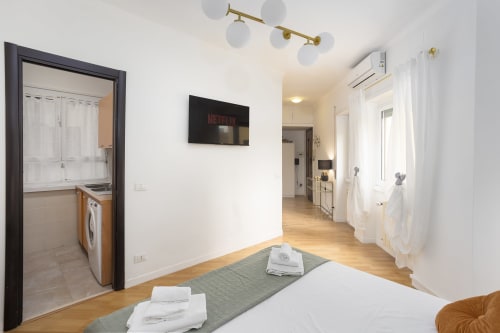 Camera moderna dell'hotel Re di Roma a Roma con pavimento in legno, TV, lavatrice e vista sulla città