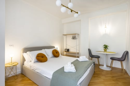 Camera da letto moderna dell'hotel Re di Roma a Roma con letto, zona di lavoro e arredamenti minimalisti