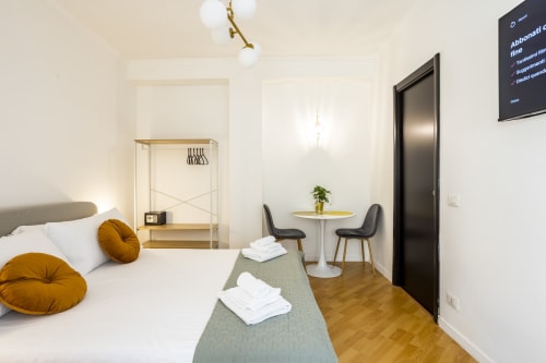 Camera da letto dell'appartamento Re di Roma con letto, zona living e vista sulla città di Roma