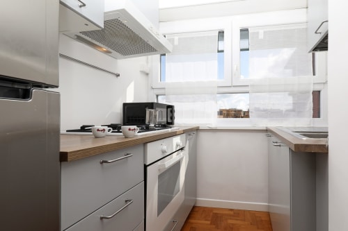 Cucina moderna dell'appartamento Re di Roma a Roma con elettrodomestici in acciaio inox, top in legno e vista sulla città