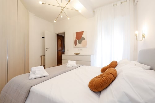Camera moderna dell'appartamento Re di Roma a Roma con letti gemelli, biancheria bianca e arredamento contemporaneo