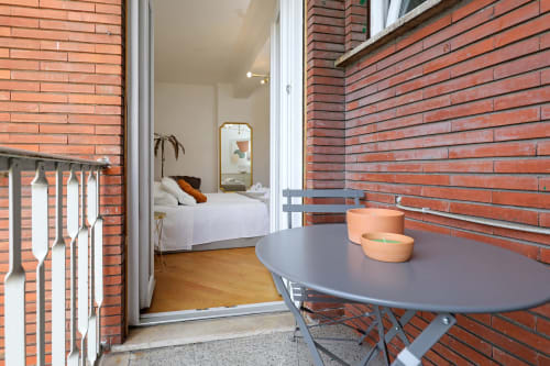 Balcone dell'appartamento Re di Roma con tavolo e candele affacciato sulla camera da letto con vista sulla città, Roma
