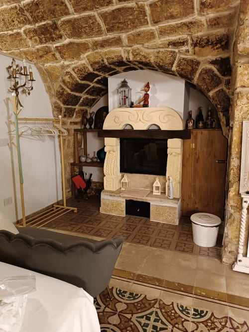 Sala con volta in pietra, camino decorativo, arredi in legno e décor vintage dell'hotel CorteLirice Paradiso in Italia