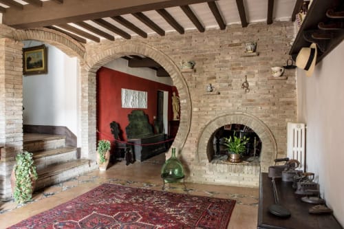 Interni rustici di Villa Pandolfi Elmi a Spello con archi in laterizio, camino e arredamento tradizionale italiano
