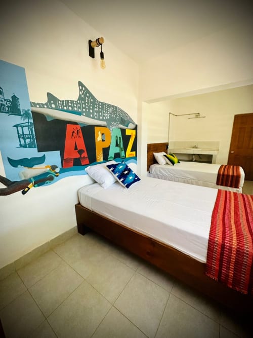Habitación infantil colorida en BajaReal Hotel Boutique de La Paz con mural de ballena, dos camas y decoración vibrante