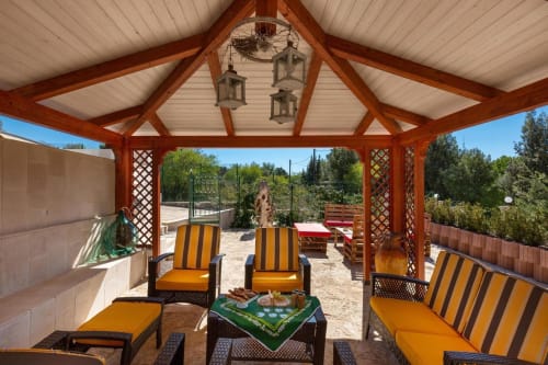 Area lounge coperta di Villa Margherita con sedie a strisce con vista sui giardini di Santeramo in Colle