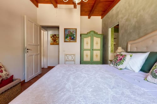 Camera spaziosa a Villa Margherita con letto matrimoniale, armadio verde, soffitto in legno e arredamento tradizionale a Santeramo
