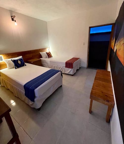 Habitación del Hotel Boutique BajaReal con dos camas, mobiliario de madera y vista a la ciudad en La Paz