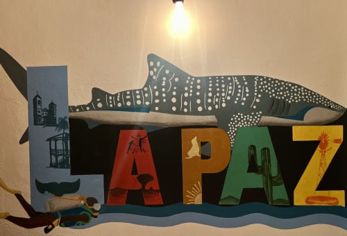 Colorido letrero de La Paz con ballena y escenas del desierto en el BajaReal Hotel Boutique de Baja California Sur, México