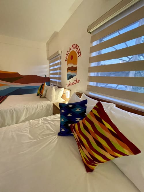 Habitación luminosa en BajaReal Hotel Boutique de La Paz con cojines coloridos del suroeste y arte inspirador en las paredes