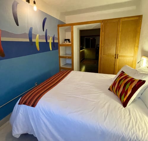 Habitación colorida en BajaReal Hotel Boutique de La Paz con arte temático marino y almohadas rayadas