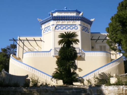 Hotel Panoramici Monolocali a Leuca con facciata bianca, dettagli tetto blu, palma e terrazze curve