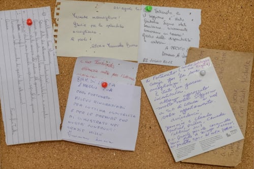 Lettere e biglietti manoscritti appuntati su una bacheca in sughero presso Panoramici Monolocali a Leuca