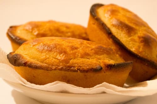 Madeleine dorate appena sfornate su piatto bianco a Panoramici Monolocali, Leuca