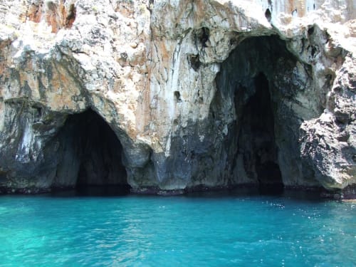 Grotte del mare turchese con scogliere di calcare bianco a Leuca, Italia, vicino all'hotel Panoramici Monolocali