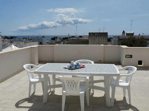 Terrazza panoramica ai Monolocali Panoramici di Leuca con tavolo da pranzo con vista sul mare e il paesaggio costiero