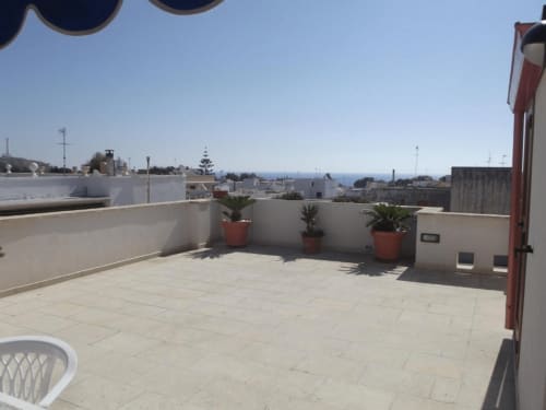 Terrazza panoramica ai Monolocali Panoramici di Leuca con vista mare, piante in vaso e paesaggio costiero