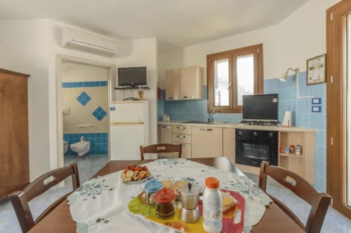 Cucina e zona pranzo del monolocale Panoramici a Leuca con dettagli in maiolica blu e vista sul mare