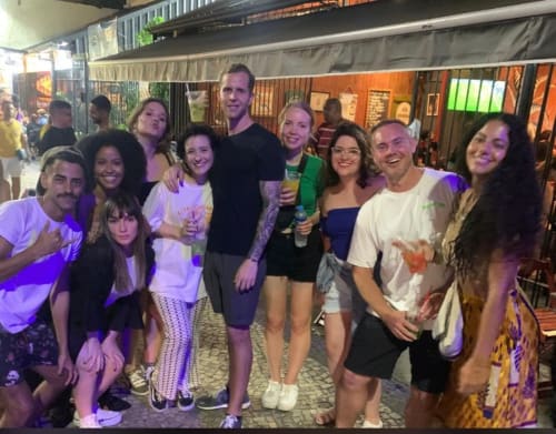 Grupo de hóspedes posando juntos na Hostel New Ipanema no Rio de Janeiro, aproveitando a vida noturna e ambiente social
