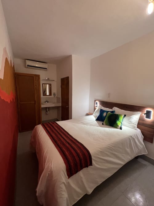 Habitación moderna del Hotel Boutique BajaReal en La Paz con cama queen, muebles de madera y baño privado