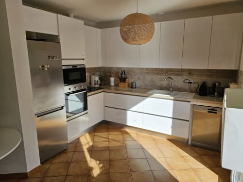 Modern kitchen at Villa Sigahi in La Croix Valmer with white cabinetry, wooden counters, stainless steel appliances, and