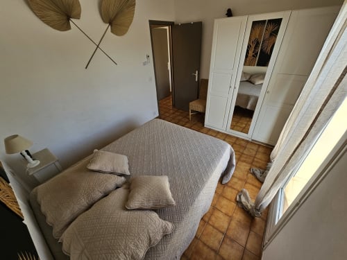 Bright bedroom at Villa Sigahi B&B in La Croix Valmer with queen bed, white wardrobe, and terracotta floors